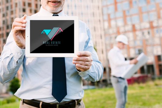 Free Architect Holding A Tablet Mock-Up In Front Of A Building Psd