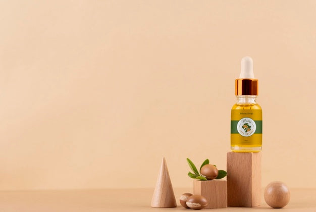 Free Argan Oil Cosmetic Bottle Mock-Up With Wooden-Shaped Podium And Kernels Psd