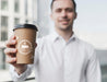 Free Business Man Holding Up A Coffee Cup Mock-Up Psd