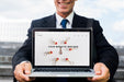 Free Businessman Presenting Laptop Mockup Psd