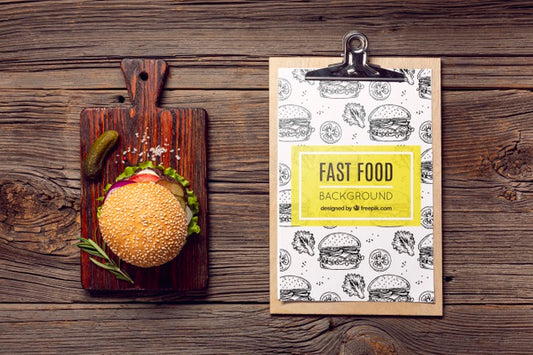 Free Clipboard And Burger On Wooden Background Psd