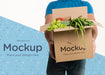 Free Front View Delivery Man Holding A Box With Different Vegetables Psd