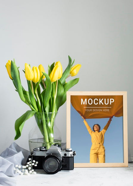 Free Front View Of Frame With Bouquet Of Tulips In Vase And Camera Psd