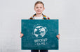 Free Front View Young Boy Holding Mock-Up Sign Psd