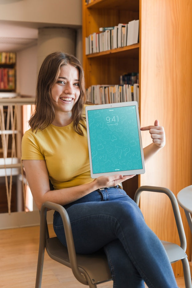 Free Happy Woman Holding Tablet Mockup In Library Psd