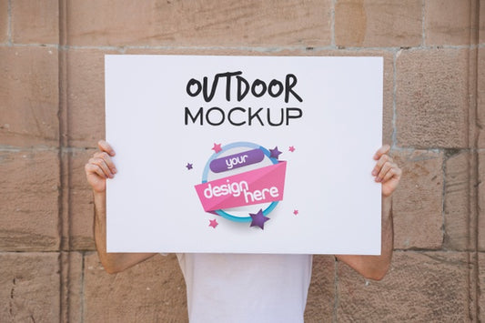 Free Man Presenting Poster Mockup In Front Of Brick Wall Psd