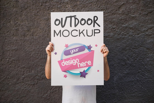Free Man Presenting Poster Mockup In Front Of Wall Psd