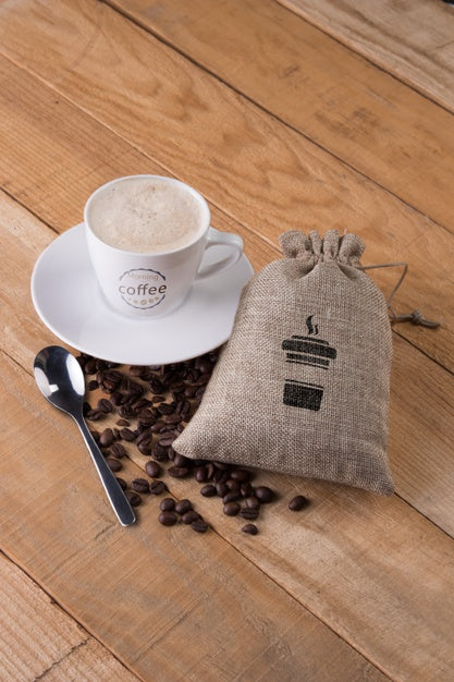 Free Mug With Bag Of Coffee Beans On Table Psd