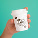 Free Person Holding Up A Coffee Paper Cup On Blue Background Psd