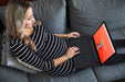 Free Pregnant Woman On Couch Using Computer Psd