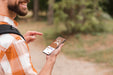 Free Side View Of Smiley Man Holding Smartphone While Camping Psd