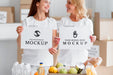 Free Smiley Female Volunteers Holding Blank Papers Next To Food Box Psd