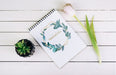 Free Spring Notebook Mockup With Decorative Plant In Top View Psd