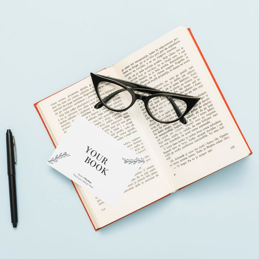 Free Top View Of Open Book With Glasses And Card Psd