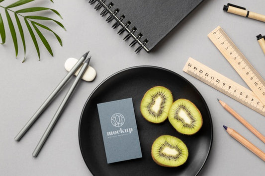 Free Top View Of Paper Stationery On Plate With Kiwi And Rulers Psd