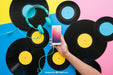 Free Vinyl Mockup With Hand Holding Smartphone Psd