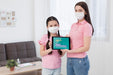 Free Woman And Daughter Holding A Tablet Mock-Up With Covid-19 Presentation Psd
