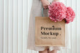 Free Woman Holding A Woven Tote Bag Mockup With Pink Hydrangea Flowers Psd
