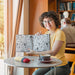 Free Woman Holding Book Mockup In Library Psd